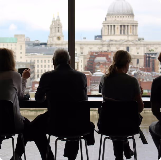A group of people sitting in front of a large window